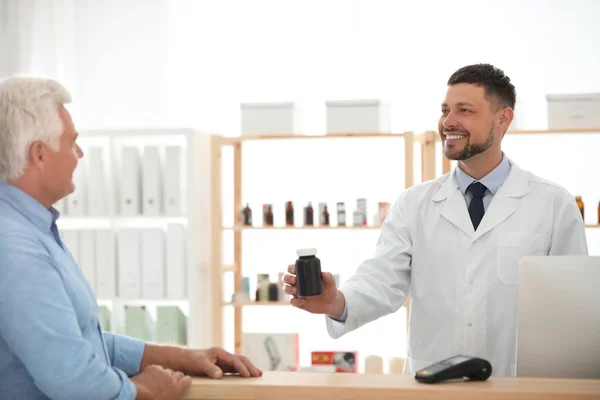 Apotheker gibt Kunde in Drogerie Medikamente — Stockfoto