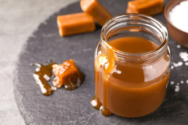 Delicioso Caramelo Salado Tarro Sobre Pizarra —  Fotos de Stock