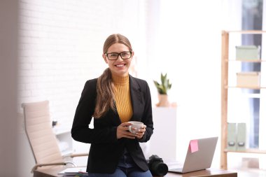İş yerindeki açık ofiste kahveli genç gazeteci