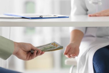Hasta klinikte masa altı doktoruna rüşvet veriyor, yakın plan. C