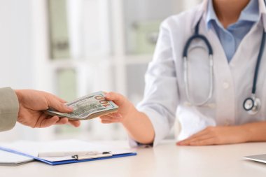 Hasta klinikteki doktora rüşvet veriyor, yakın plan. Yozlaşmış tıp