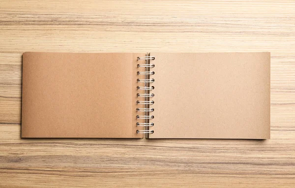 Notebook aberto elegante na mesa de madeira, vista superior. Espaço para desig — Fotografia de Stock