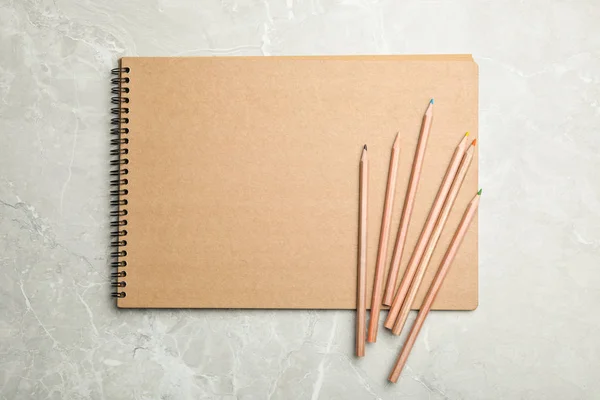 Elegante cuaderno y lápices en la mesa de mármol, vista superior — Foto de Stock
