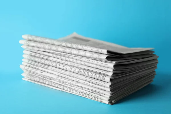 Pilha de jornais sobre fundo azul claro. Trabalho de jornalista — Fotografia de Stock