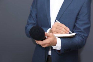 Profesyonel gazeteci karanlık arkaplan ve yakın plan hakkında notlar alıyor.