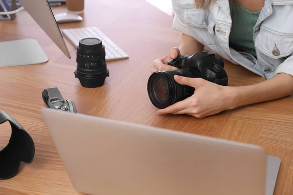 Professional photographer with camera working at table in office — 스톡 사진
