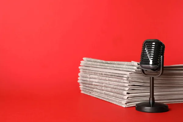 Газети та старовинний мікрофон на червоному тлі, простір для т — стокове фото