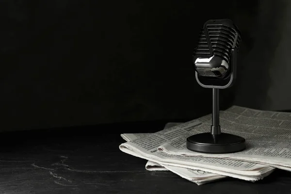 Kranten en vintage microfoon op donkere stenen tafel, ruimte voor — Stockfoto