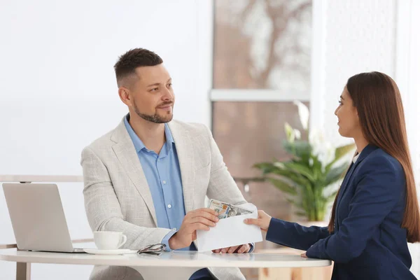 Vrouw Geeft Steekpenningen Aan Man Aan Tafel Binnen — Stockfoto