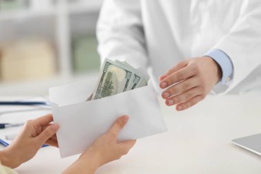 Hasta klinikteki doktora rüşvet veriyor, yakın plan. Yozlaşmış tıp