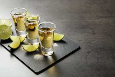 Gri masada tuzlu ve limon dilimli Meksika tekila shot 'ları. Metin için boşluk