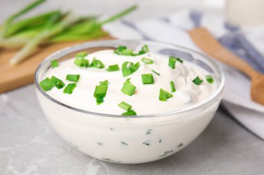 Gri mermer masada soğanlı taze ekşi krema, yakın plan.