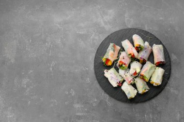 Birçok rulo pirinç kağıdına sarılı gri masa, üst manzara. Metin için boşluk