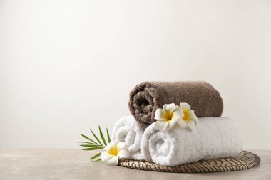 Gri mermer masa üzerinde hafif arkaplanlı Plumeria çiçekleriyle güzel bir spa kompozisyonu. Metin için boşluk