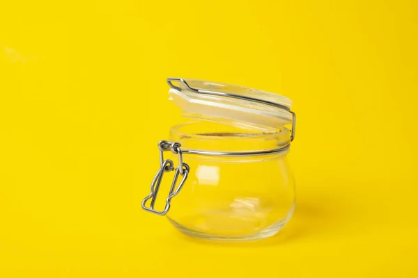 Frasco de vidro vazio aberto no fundo amarelo — Fotografia de Stock