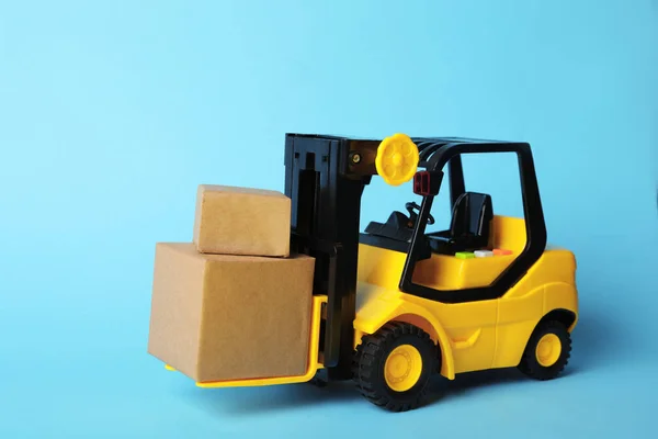 Toy Forklift Dengan Kotak Latar Belakang Biru Logistik Dan Konsep — Stok Foto