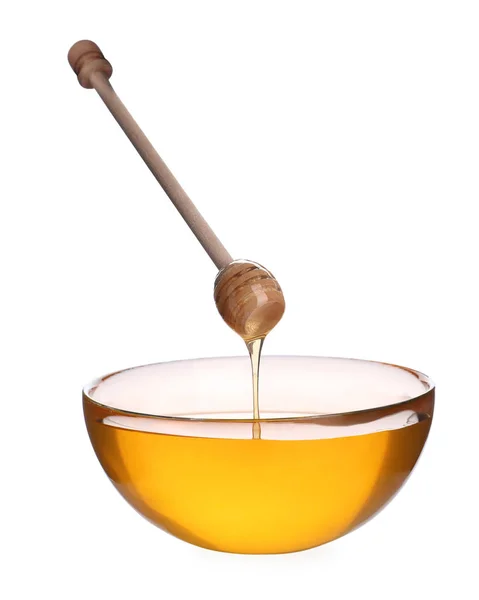 Мед, капающий из деревянной ковши в чашу, изолированную на белом — стоковое фото