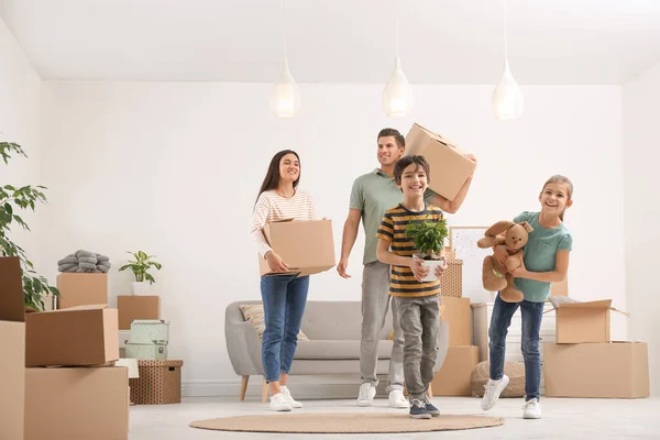 Happy family in room with cardboard boxes on moving day — Stock Photo, Image