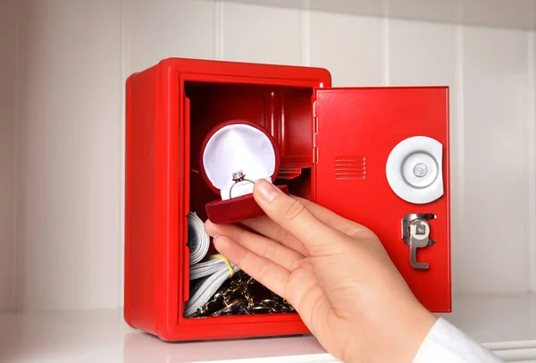 Woman Putting Jewelry Red Steel Safe Shelf Closeup — ストック写真