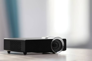 Beyaz masa içerisindeki modern video projektörü. Metin için boşluk