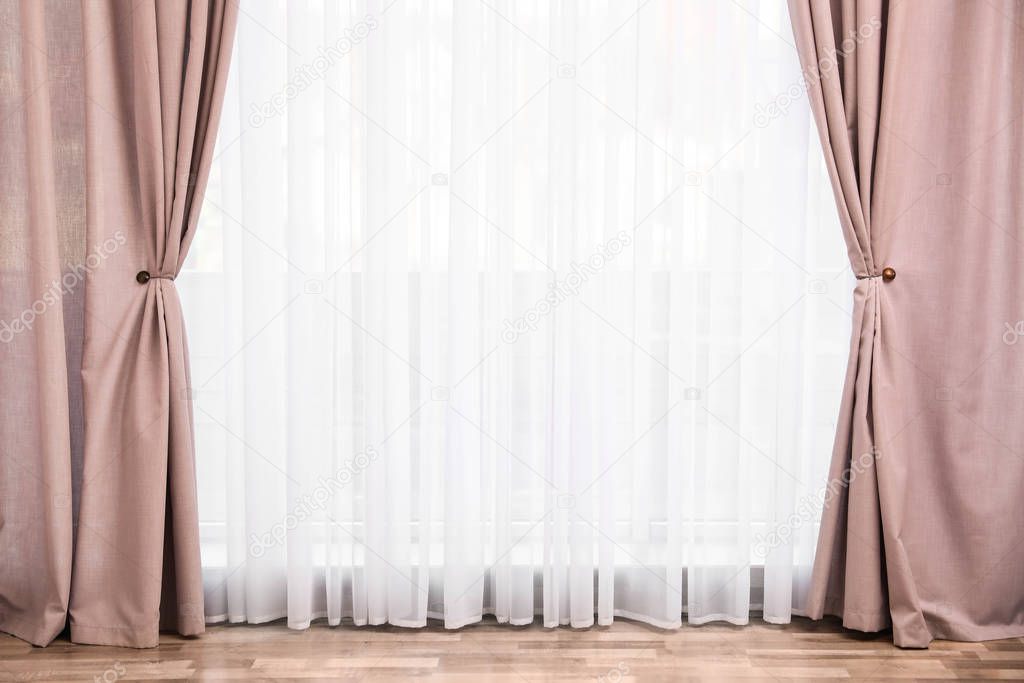 Window with elegant curtains in empty room