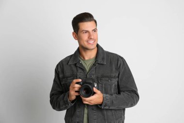 Stüdyoda beyaz arka plan üzerinde çalışan profesyonel fotoğrafçı.