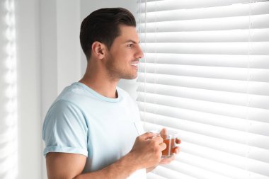 Pencerenin yanında çay içen adam. Tembel sabah