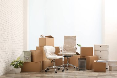 Moving boxes and stuff near white brick wall in room clipart