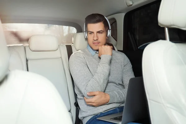 Hombre guapo escuchando audiolibro en el coche — Foto de Stock