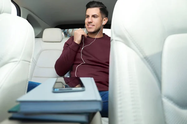 Человек с мобильным телефоном слушает аудиокнигу в машине — стоковое фото