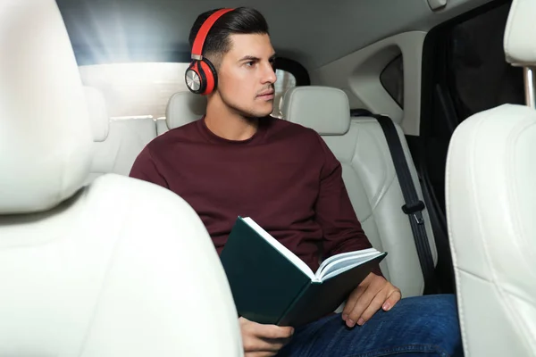 Hombre guapo escuchando audiolibro en el coche —  Fotos de Stock