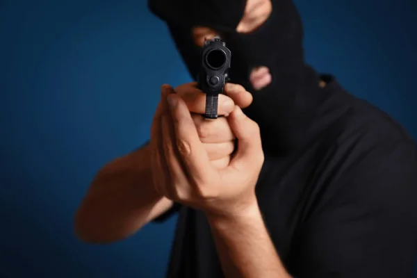 Homem Máscara Segurando Arma Contra Fundo Azul Escuro Foco Mãos — Fotografia de Stock