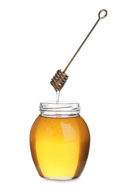 Honey dripping from dipper into jar isolated on white