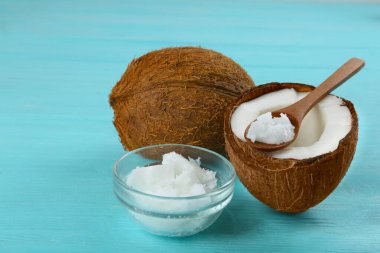 Açık mavi ahşap masa üzerinde organik hindistan cevizi yağı ile kompozisyon. Sağlıklı yemek.