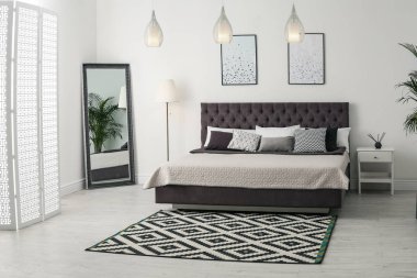 Modern, rahat, aynalı bir yatak odası.