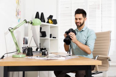 Ofiste çalışan kameralı profesyonel fotoğrafçı.