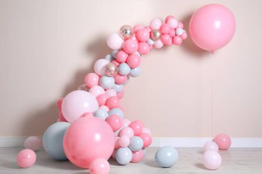 Beautiful composition with balloons near beige wall