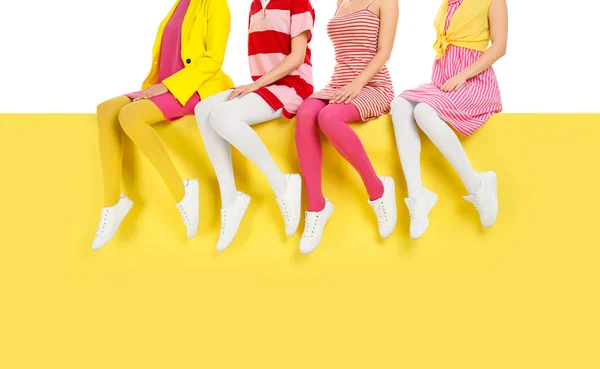 Las mujeres que usan medias brillantes sentadas en el fondo de color, primer plano — Foto de Stock