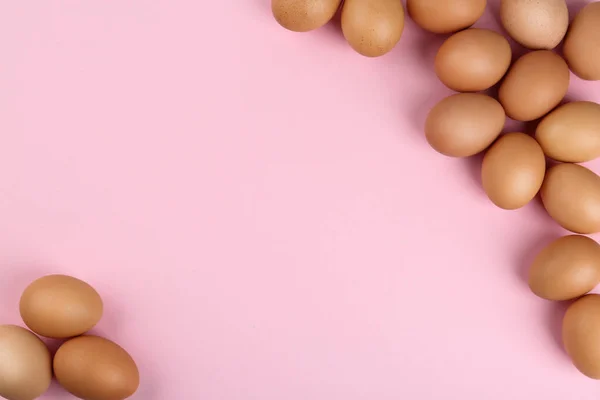 Raw chicken eggs on pink background, flat lay. Space for text