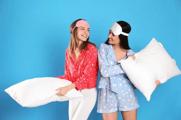 Beautiful women with pillows on light blue background. Bedtime — 스톡 사진
