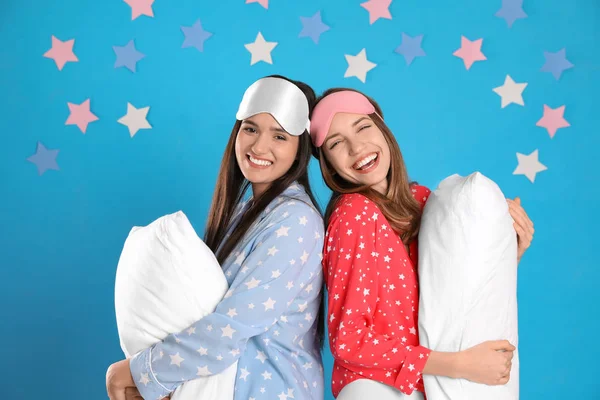 Hermosas mujeres con almohadas sobre fondo azul claro. Hora de dormir —  Fotos de Stock