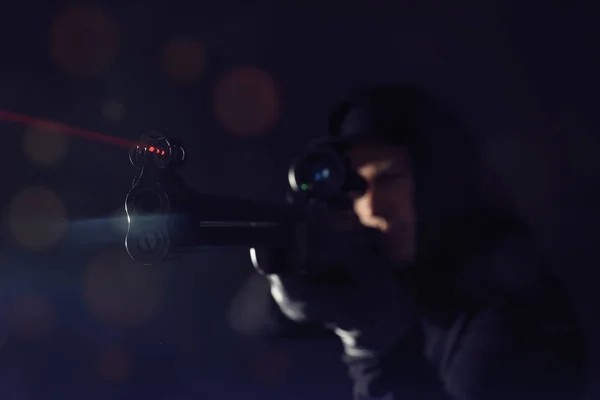 Professional killer on black background, focus on sniper rifle — Stock Photo, Image