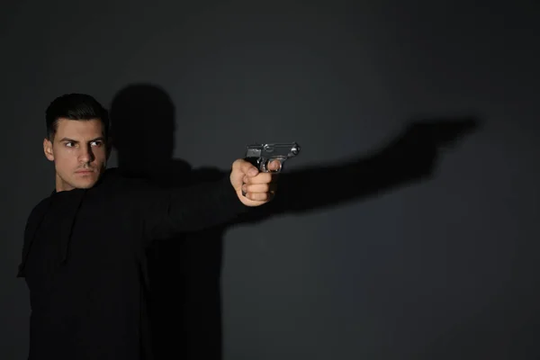 Pembunuh profesional dengan senjata di latar belakang hitam — Stok Foto
