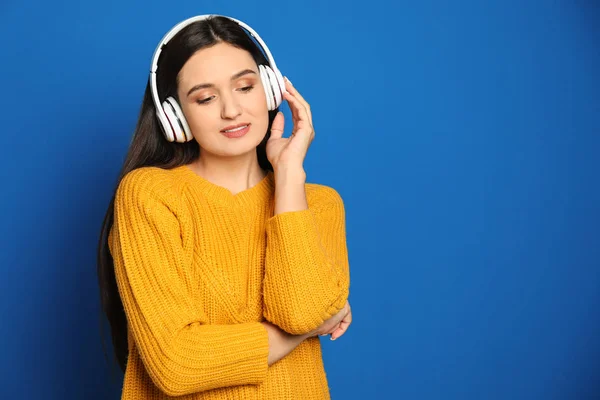 Молодая Женщина Слушает Аудиокнигу Синем Фоне Пространство Текста — стоковое фото