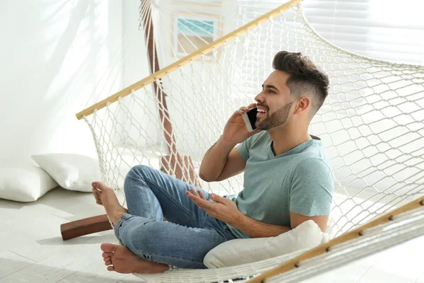 Young Man Talking Mobile Phone Hammock Home — 스톡 사진