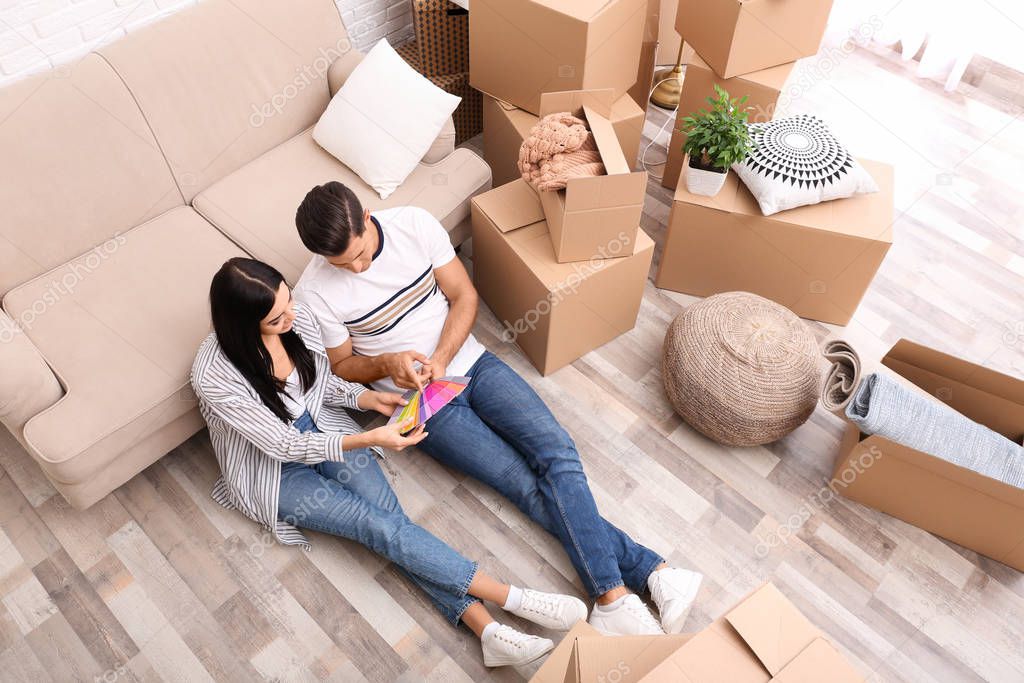 Couple with color palette samples in their new flat on moving da