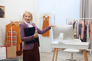 Butikte panosu olan bir kadın işyeri sahibi.