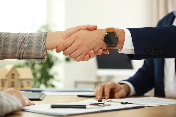 Real estate agent shaking hands with client in office, closeup — 스톡 사진