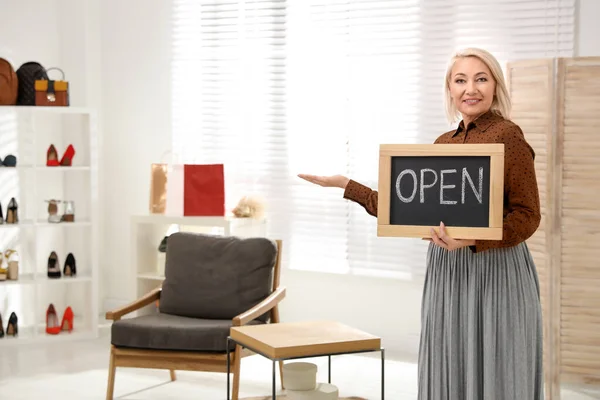 Propietaria de una empresa femenina que sostiene el cartel OPEN en boutique. Espacio para t — Foto de Stock