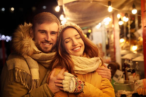 Glada par spenderar tid på julmarknad — Stockfoto